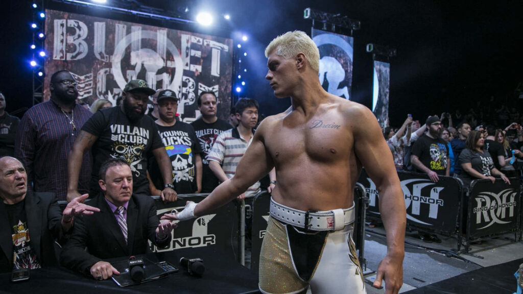 Cody Rhodes wrestling event wallpaper with intense lighting crowd and athletic physique closeup