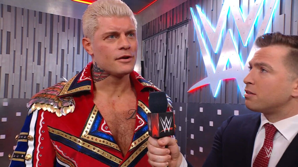 WWE wrestler Cody Rhodes in ornate red jacket backstage interview vibrant WWE logo background Wallpaper