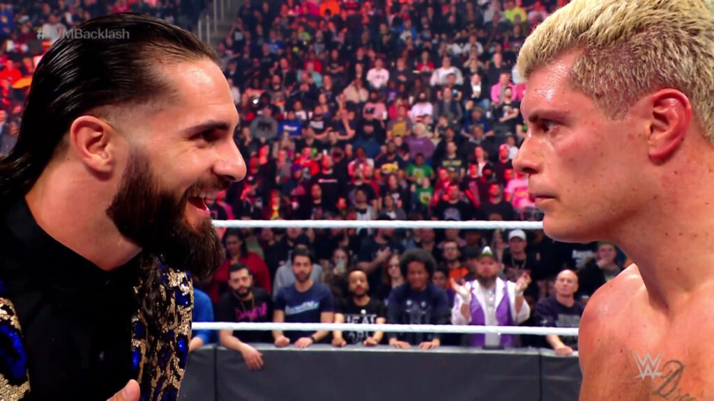 Cody Rhodes and Seth Rollins intense WWE faceoff in vibrant arena with glowing ring lights wallpaper