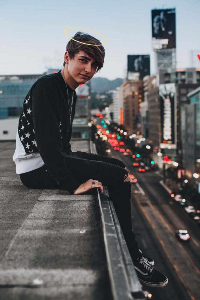 Colby Brock on rooftop at dusk with glowing city lights and digital halo in urban background Wallpaper