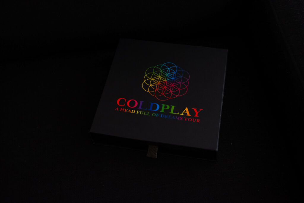 Coldplay A Head Full of Dreams Tour box with vibrant multicolored geometric logo on black Wallpaper
