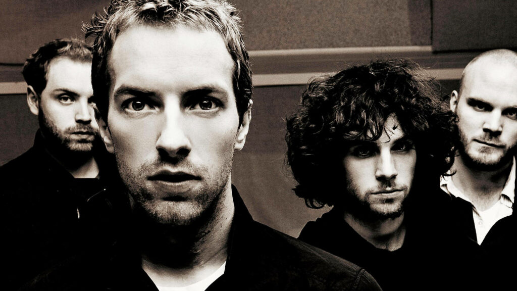 Coldplay band wallpaper showing all four members in a vibrant expressive group portrait background