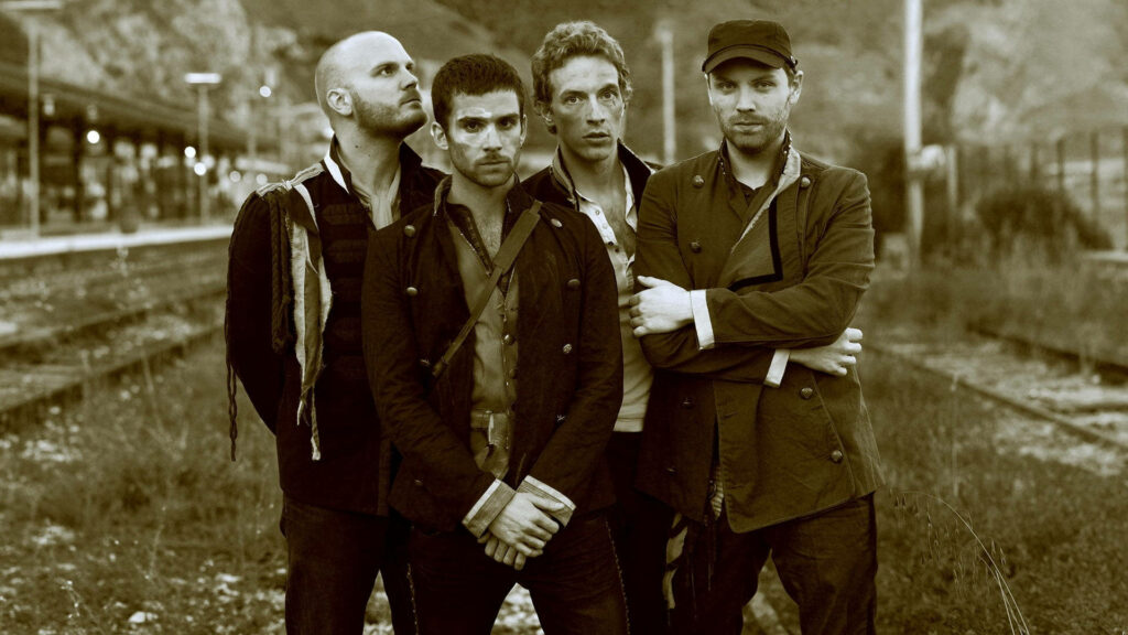 Coldplay band members on vintage sepia train tracks nostalgic wallpaper background image