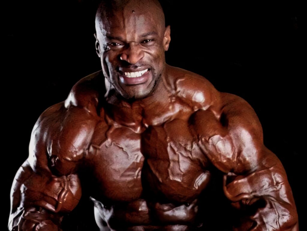 Coleman the bodybuilder flexes muscular physique with intense expression on dark dramatic background Wallpaper
