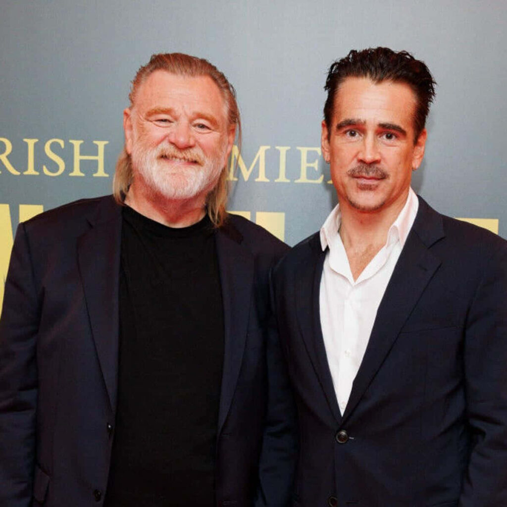 Colin Farrell and Brendan Gleeson in classic dark suits at formal event blue gold backdrop wallpaper
