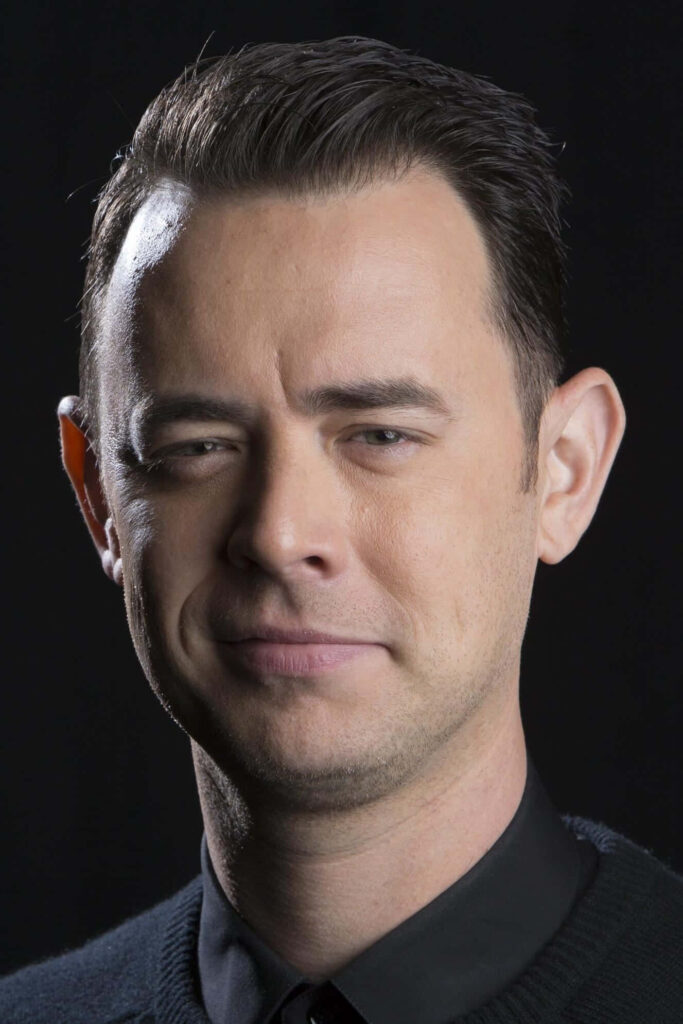 Colin Hanks close-up portrait wallpaper with soft lighting and dark neutral background