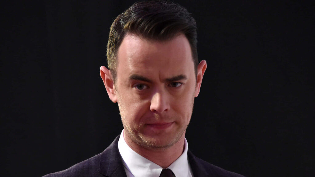 Colin Hanks sharp professional portrait in dark suit with natural lighting on black background Wallpaper