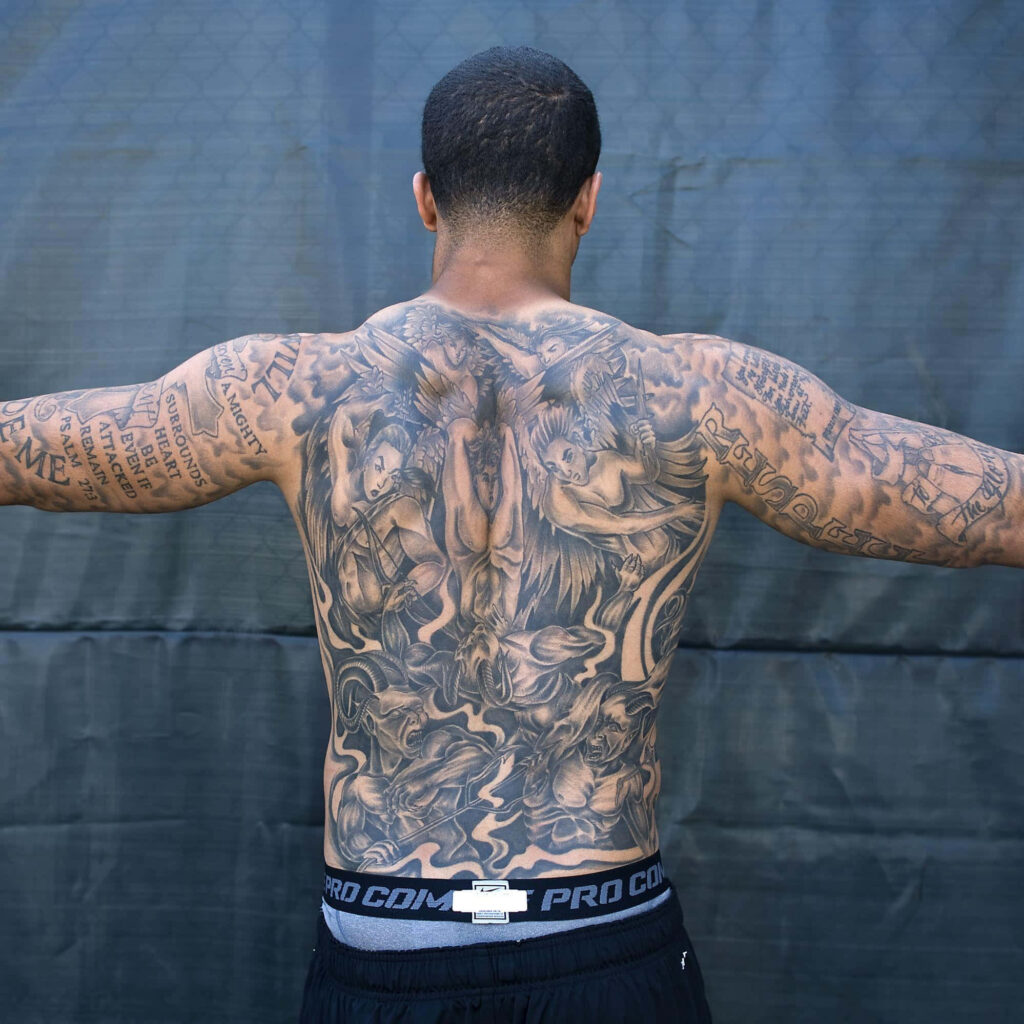 Colin Kaepernick wallpaper showing detailed black and gray full-back tattoos symbolizing strength