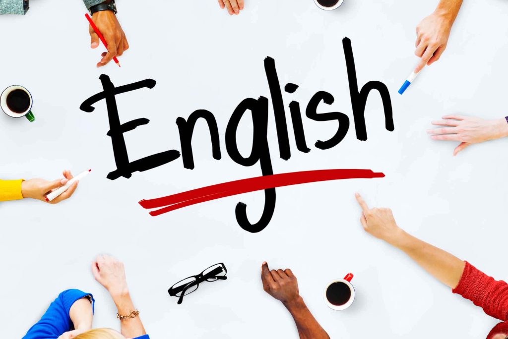 Overhead view of diverse hands around English text with markers and coffee in learning session Wallpaper