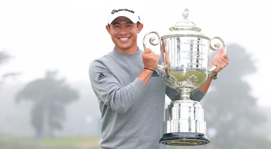 Collin Morikawa celebrates golf victory holding silver trophy in misty outdoor setting wallpaper