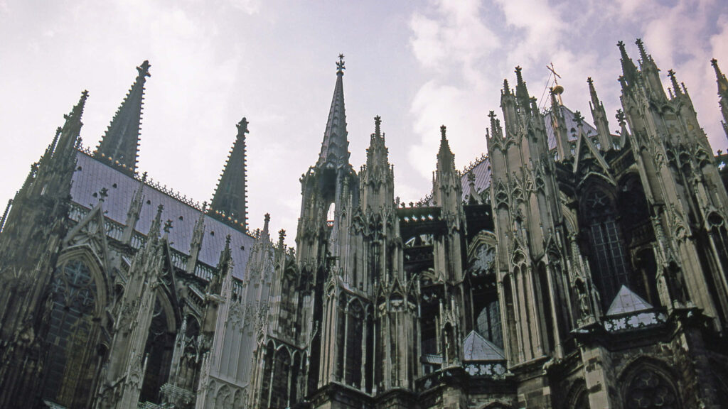 Cologne Cathedral Gothic architecture detailed spires pointed arches against cloudy sky wallpaper