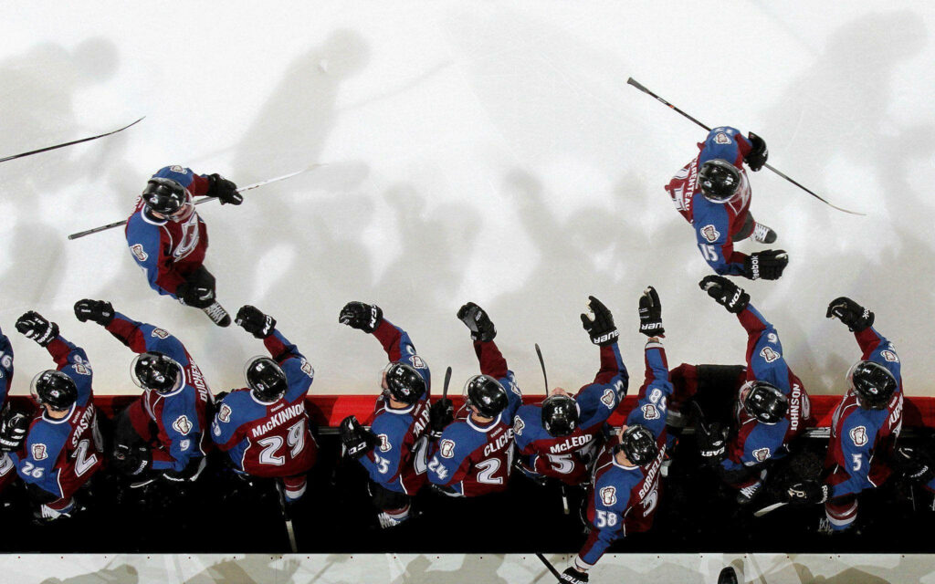 Colorado Avalanche hockey players celebrating on ice rink showcasing team unity and energy wallpaper