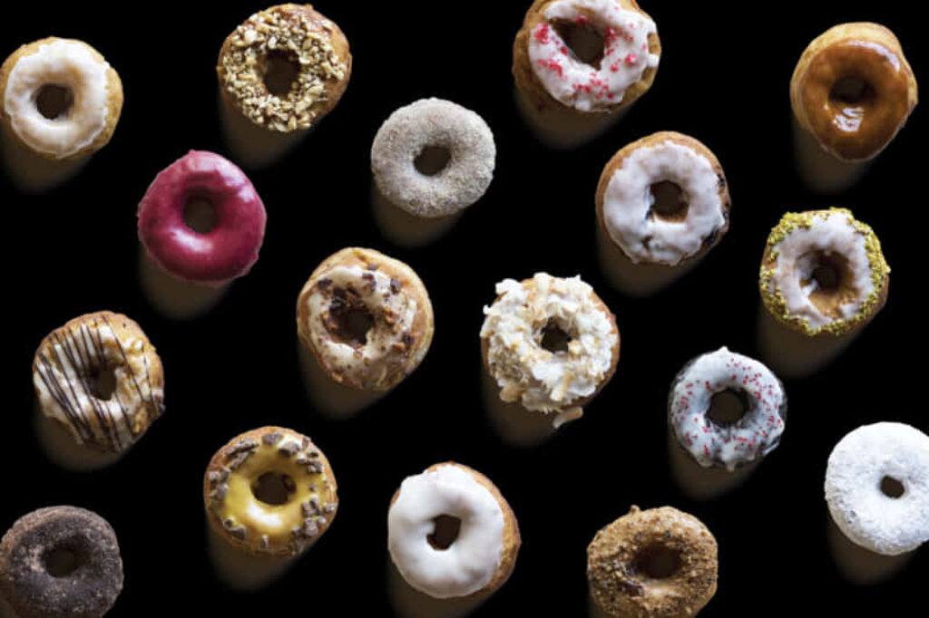 Colorful Donuts Top View: Assorted Flavors on Dark Background Wallpaper