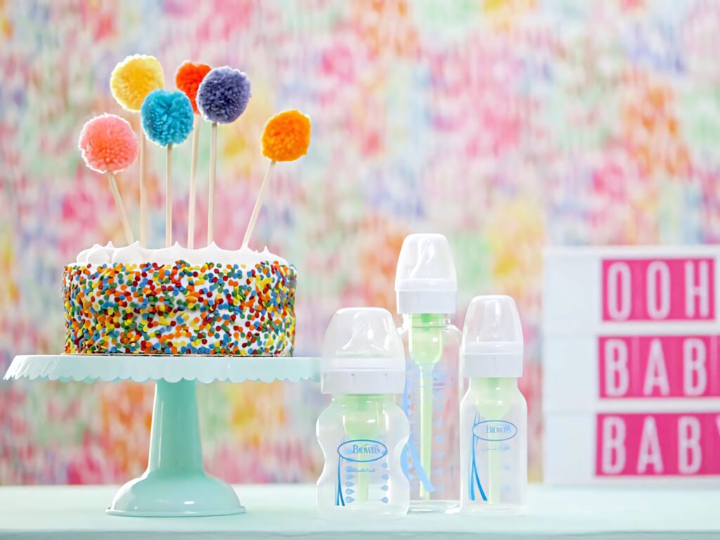 Colorful baby shower Zoom background with sprinkle cake pom-poms baby bottles pastel blocks Wallpaper