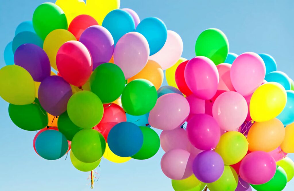 Colorful balloons floating against clear blue sky vibrant celebration wallpaper background