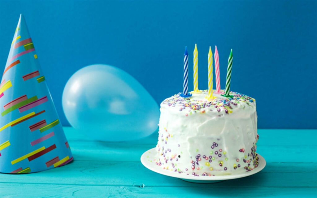 Colorful Birthday Celebration with White Cake and Cheerful Décor Wallpaper
