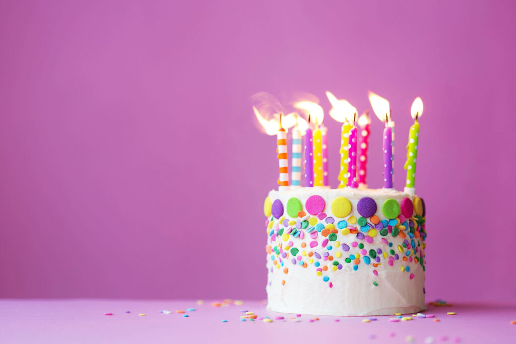 Festive Birthday Cake Wallpaper: Colorful Sprinkles & Purple Background