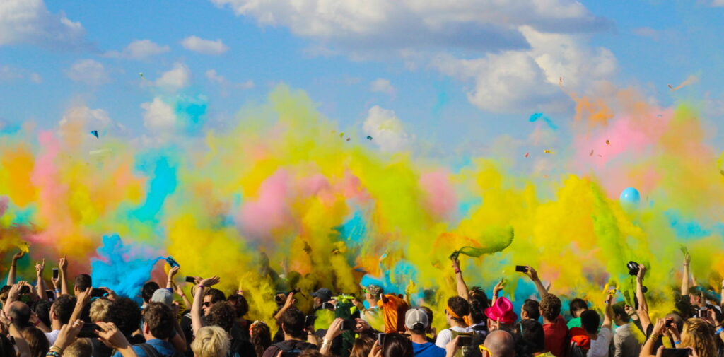 Colorful Outdoor Festivities: A Vibrant Gathering of Joyful Individuals Wallpaper