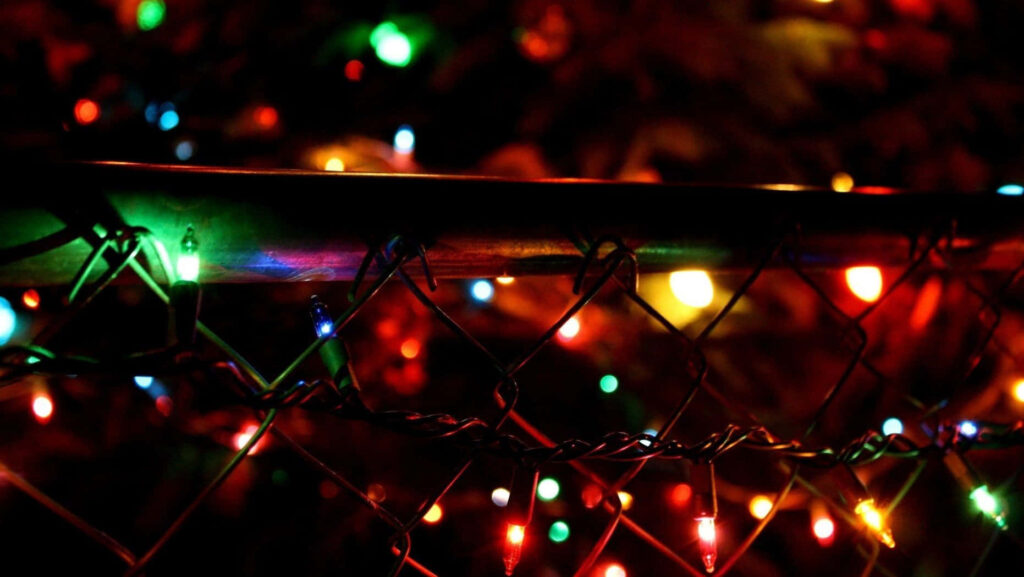 Colorful Blurred Lights Behind Chain-Link Fence Wallpaper Background