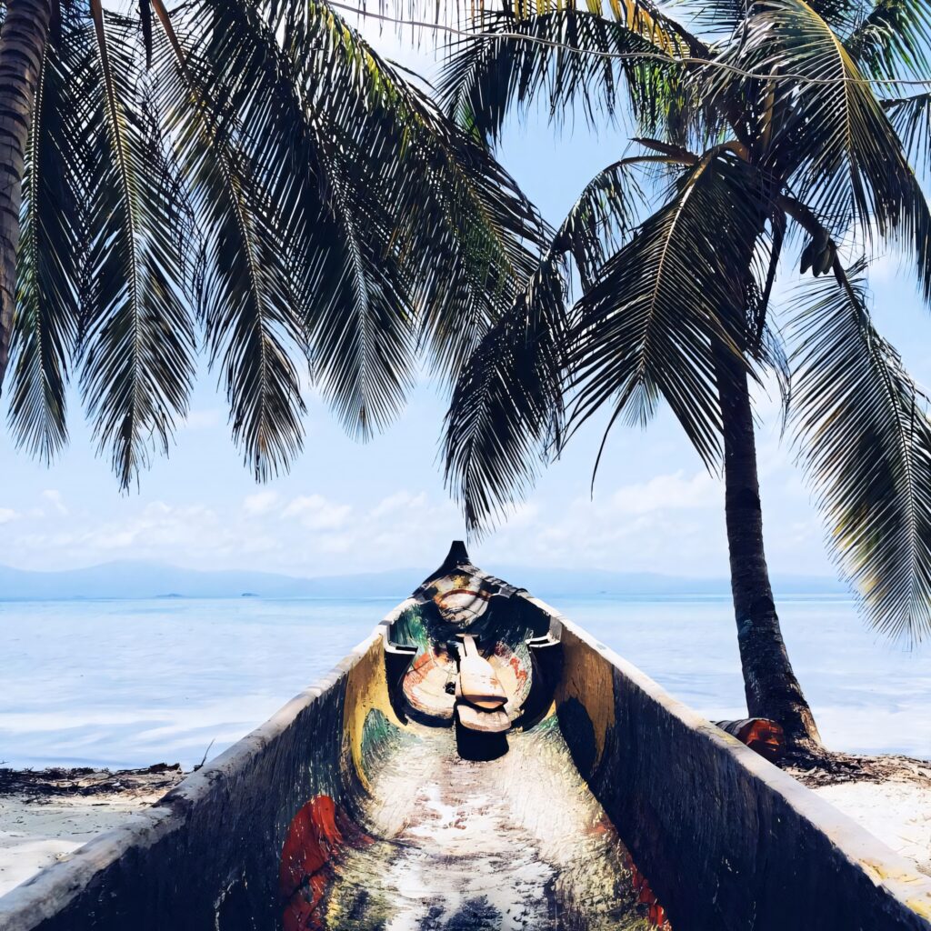 Serene Tropical Beach: Colorful Boat & Lush Palms Under Blue Sky Wallpaper