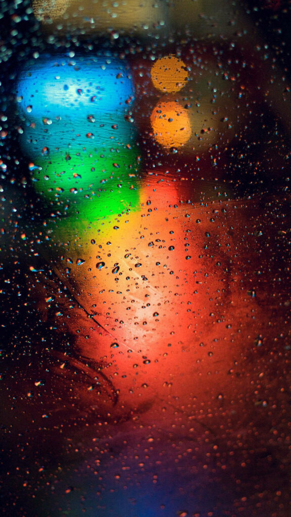Vibrant Rainy Night: Colorful Bokeh Lights Illuminating Glass Panel as Full HD Tablet Background Wallpaper