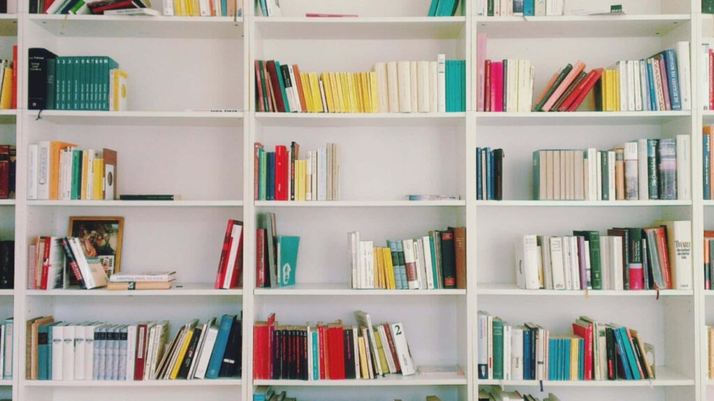 Vibrant Rainbow of Books Adorns a Home Library Desktop Wallpaper
