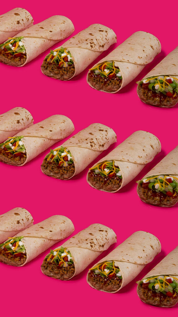 Seamless vibrant wrapped burritos pattern with colorful ingredients on bold pink background wallpaper