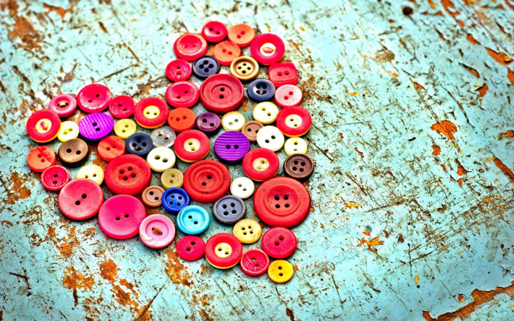 Colorful Heart-Shaped Button Wallpaper on Rustic Blue Background