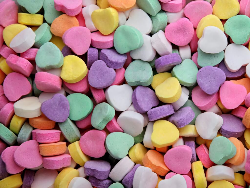 Colorful candy heart tablets wallpaper in pastel pink yellow green purple and white tones