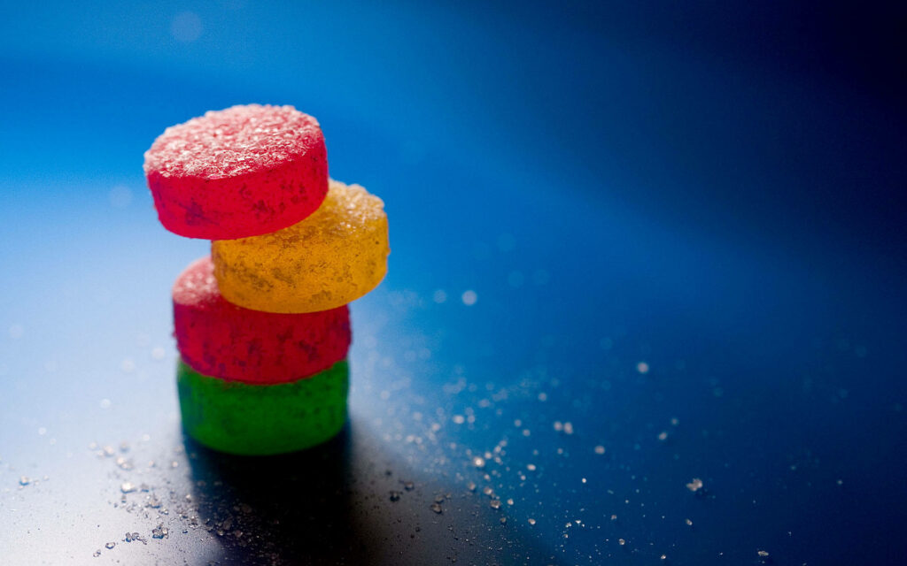 Colorful Candy Wallpaper: Sparkling 3D Desserts on Blue Background