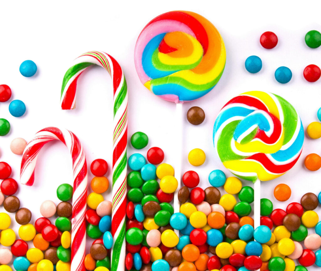 Vibrant candy wallpaper with rainbow lollipops candy canes and colorful round sweets background