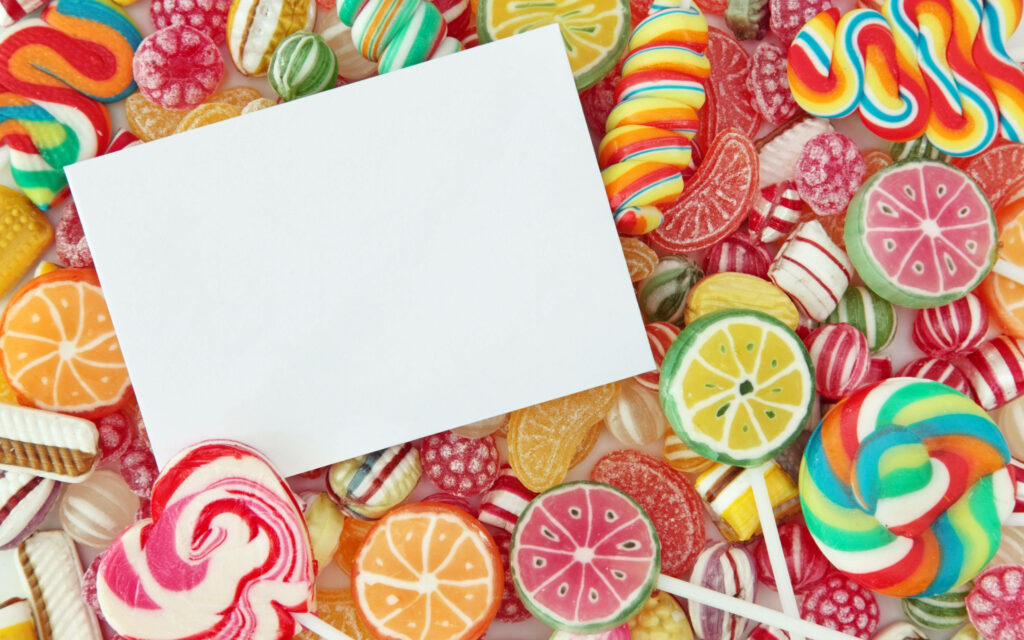 Colorful candy and lollipop wallpaper with blank white card for personalized messages background