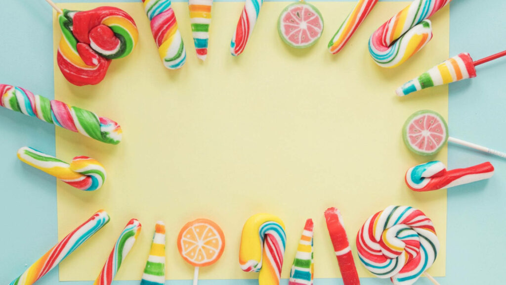 Vibrant candy and lollipop wallpaper with pastel colors and soft yellow center background design