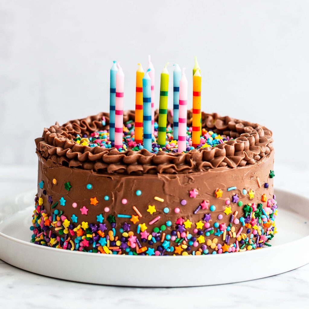 Chocolate Birthday Cake with Sprinkles & Candles on White Background Wallpaper