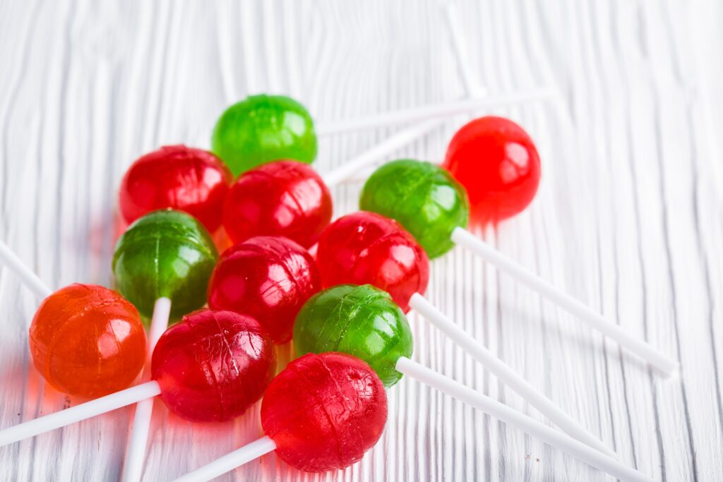 Vibrant Chupa Chups Lollipops Wallpaper on Textured White Wood