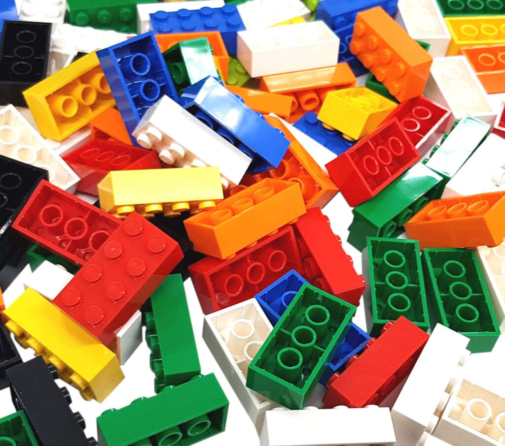 Colorful classic Lego bricks scattered playfully inspiring creativity imagination wallpaper background