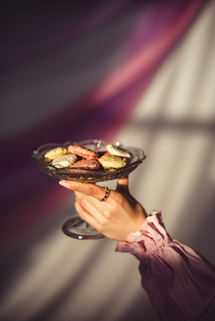Colorful Cookie Vase: Elegant Hand & Softly Lit Wallpaper Background
