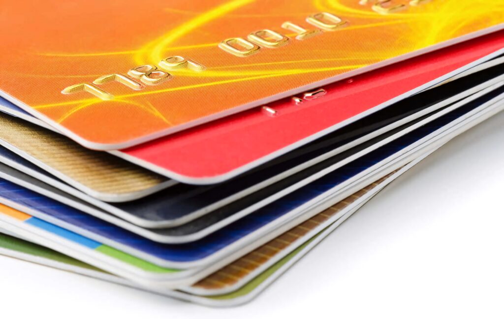 Close-up of vibrant credit cards stacked on white background showcasing modern finance tools Wallpaper