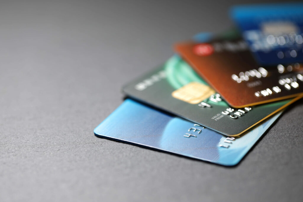 Close-up of colorful metallic credit cards fanned on gray surface showcasing secure banking technology Wallpaper