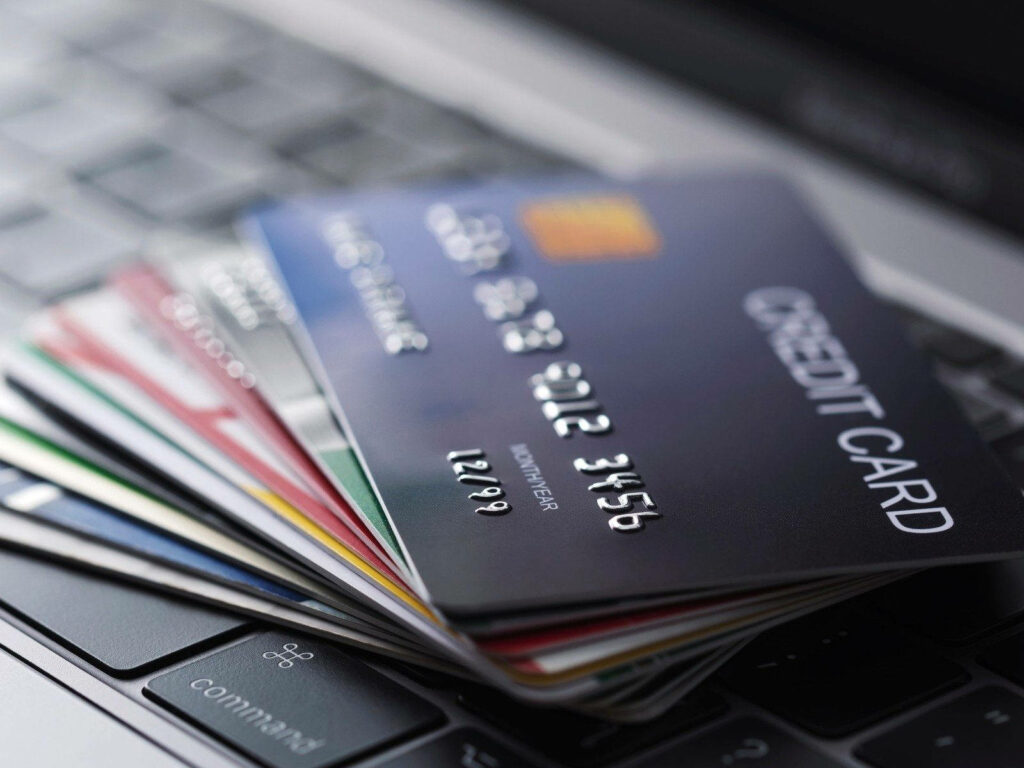 Close-up of colorful credit cards on laptop keyboard representing online payments and finance Wallpaper