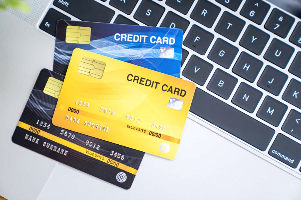 Close-up of colorful credit cards on silver laptop keyboard symbolizing digital payments and online shopping Wallpaper