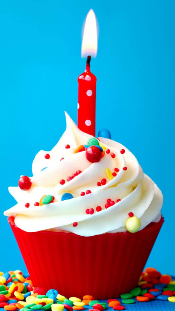 Festive Birthday Cupcake with Candies and Candle on Vibrant Blue Background Wallpaper