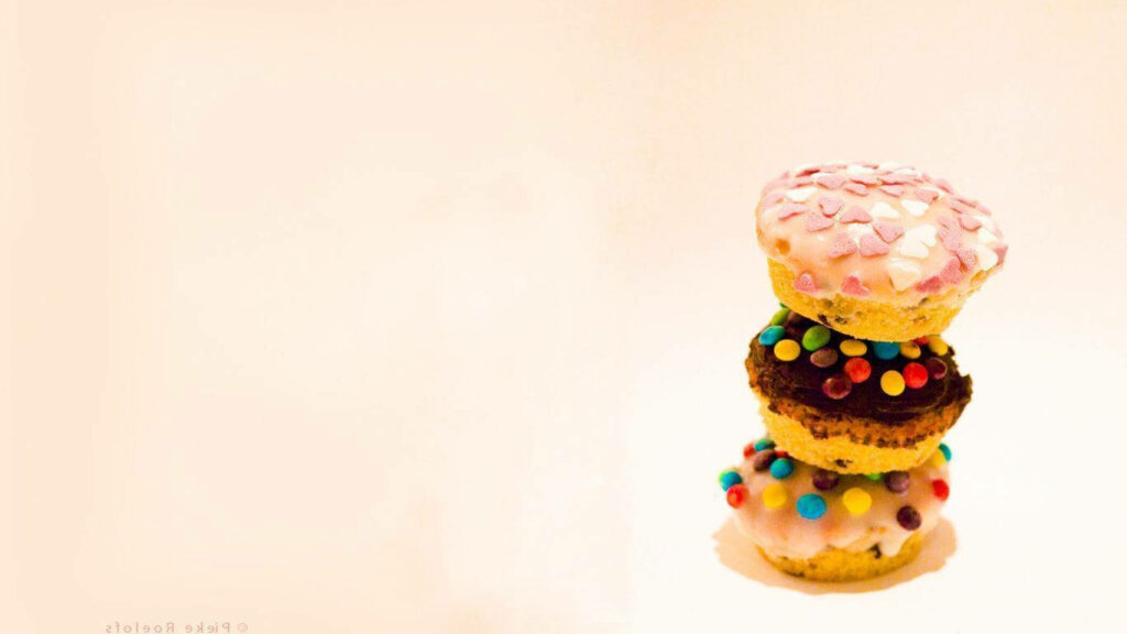 Colorful Cupcake Wallpaper: Delightful Stacked Treats on Minimalist BG