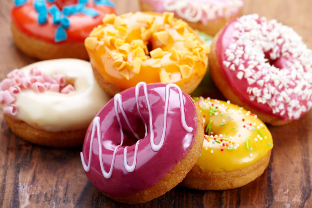 Colorful Donuts Wallpaper: Tasty Treats on Rustic Wood Background