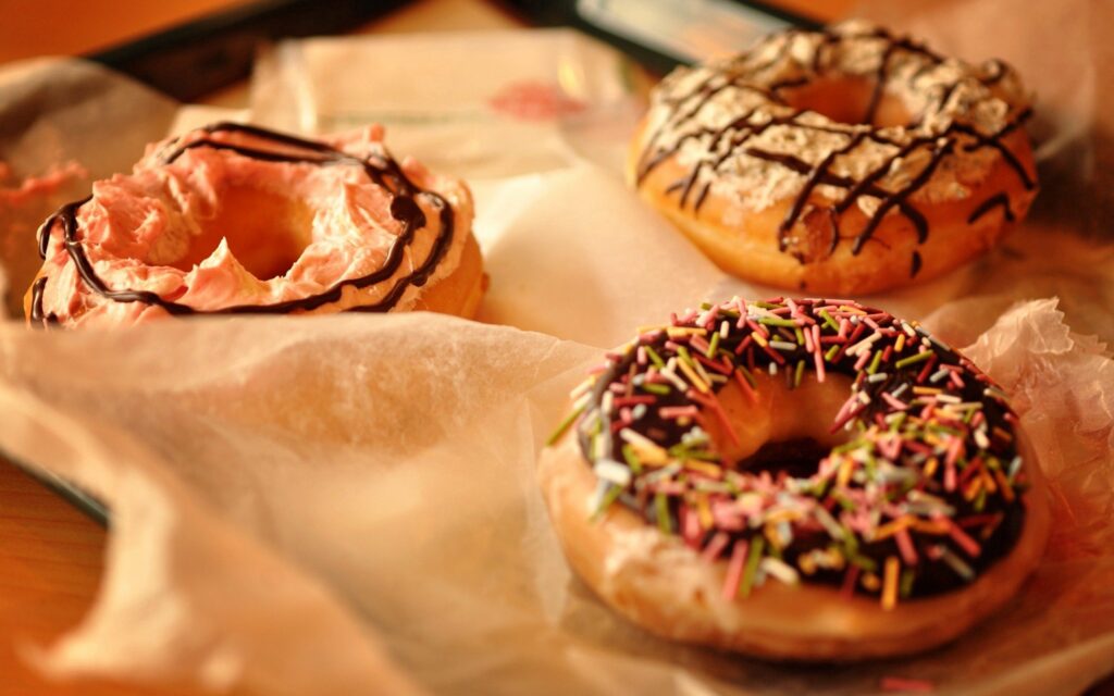 Colorful Donut Wallpaper: Mouthwatering Frosted Delight Background