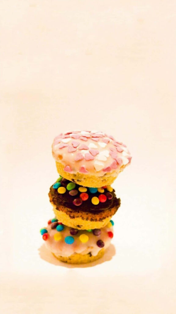 Colorful Donut Wallpaper with Heart Toppings on Minimalist Background