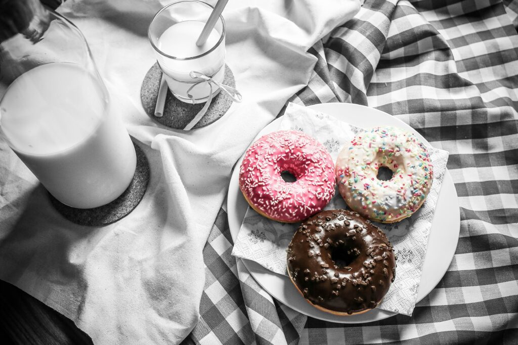 Colorful Donuts and Milk Wallpaper: Sweet Treats on Checkered Tablecloth