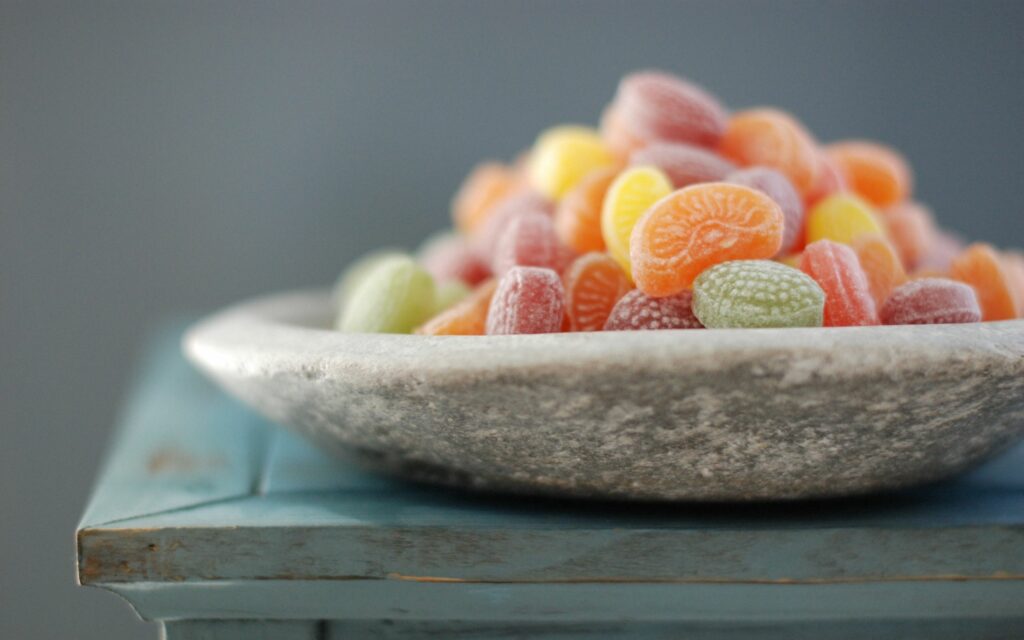 Colorful Fruit-Shaped Candy on Rustic Blue Stone Plate Wallpaper