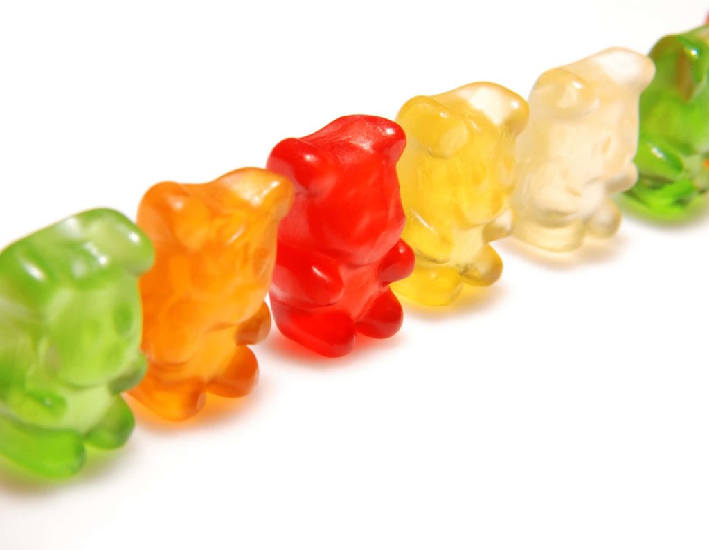 Colorful gummy bears in red green orange and yellow on white background macro photo wallpaper