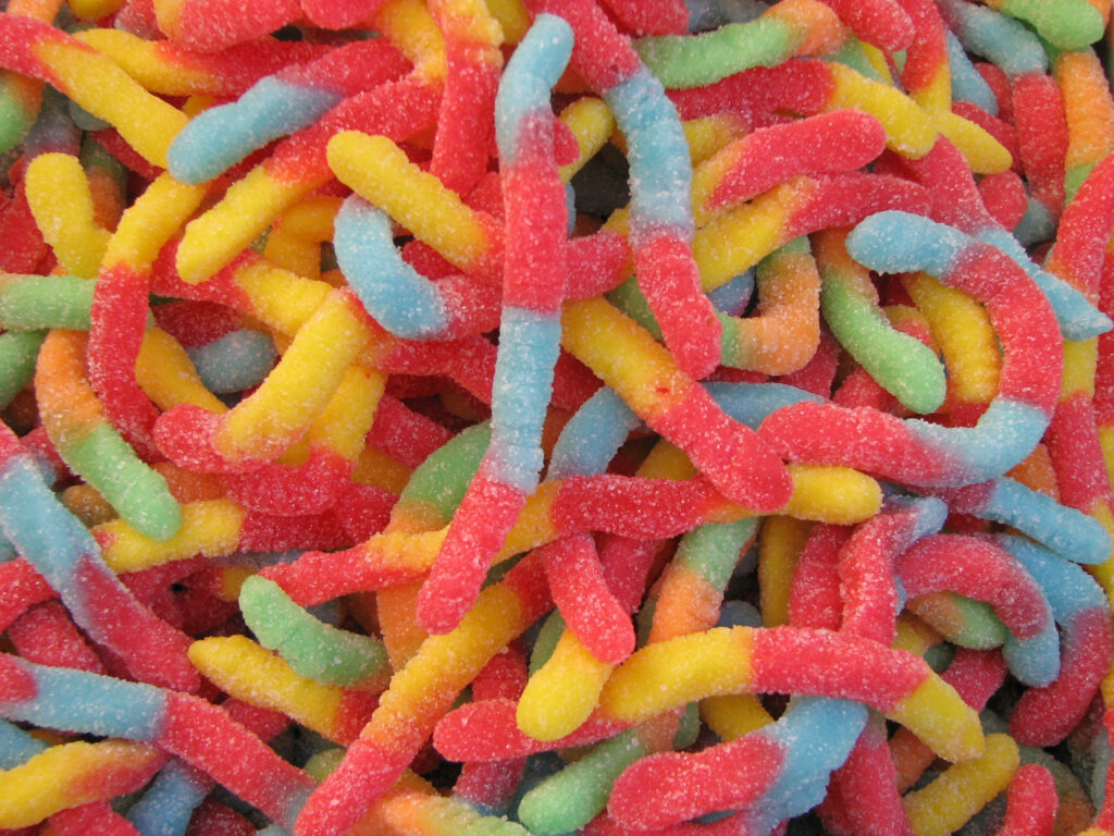 Vibrant Gummy Worm Wallpaper: Colorful Candy Background Design